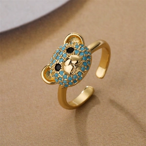 Close-up of golden copper ring featuring a micro-inlaid blue crystal teddy bear design