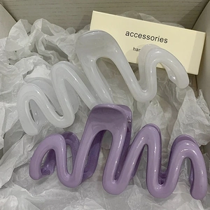 Jelly colored wavy shark hair clips in purple and white inside a minimalist gift box