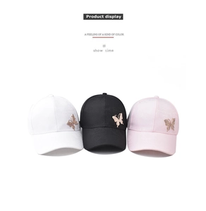 Detailed view of cotton baseball caps in white black and pink with butterfly rhinestone