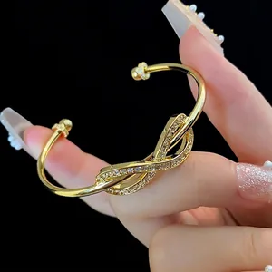 Gold-plated infinity knot open bangle with sparkling cubic zirconia pavé stones
