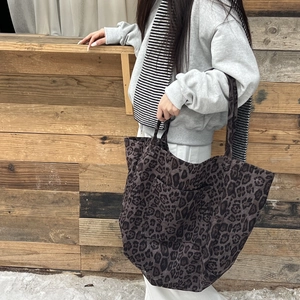 Detail shot of leopard print canvas tote bag with wide straps and external pocket