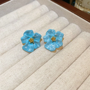 Vintage floral stud earrings with blue oil drip and marble texture in a jewelry box