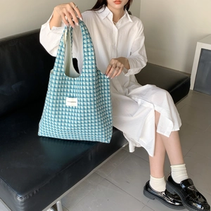 Detail of blue and white checkered woven tote bag showing texture and fabric label