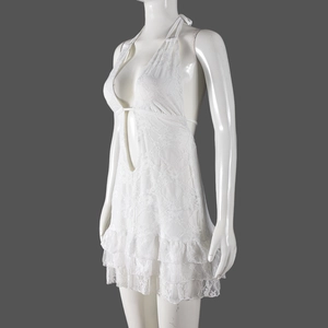 Detail of white lace halter dress with tiered ruffle hem and sheer floral textures
