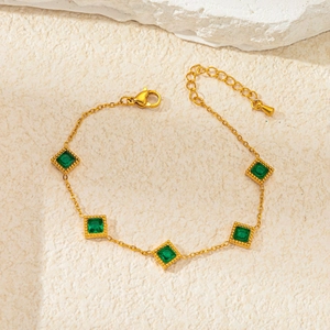 French vintage emerald zircon gold bracelet on a textured stone background for women