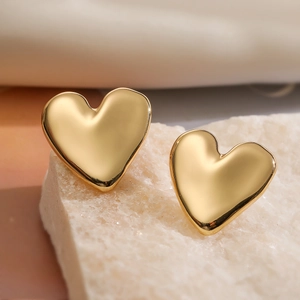 Minimalist 18K gold-plated copper heart stud earrings on a textured stone base