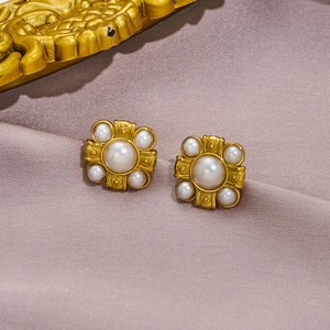 Boucles d'oreilles vintage en perles et métal doré sur fond de soie violette