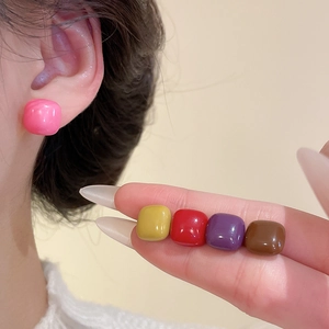 Macro detail of colorful resin square stud earrings in cherry pink and mocha brown tones