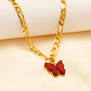 Gold Figaro anklet with dark red butterfly charm on soft silk background