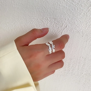 Close-up of S925 sterling silver ring with irregular textured wrinkles on a finger