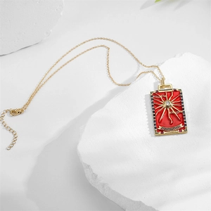 Detailed view of The Sun tarot pendant featuring red enamel and colorful gemstones