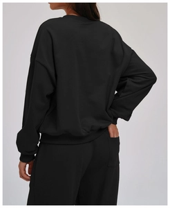 Detail of the high-quality ribbed cuffs and hem on this loose black crewneck sweatshirt