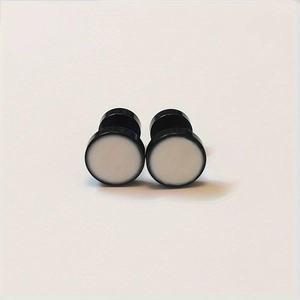 Close-up of black and white round stainless steel stud earrings on white background
