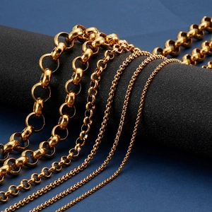 Polished gold stainless steel chains in various link sizes draped on a black pedestal