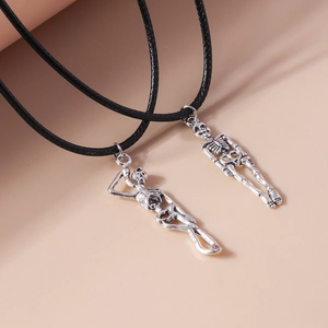 Close-up of silver skull pendant with detailed bone texture on a black wax cord necklace