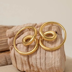 Chic 316L gold twisted round hoop earrings shown on a natural textured stone base