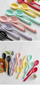Overhead view of colorful heat-resistant silicone cooking spoons on marble background