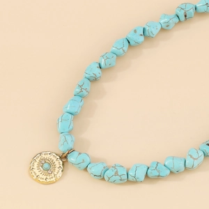 Detailed macro view of Bohemian turquoise beaded necklace with gold Evil Eye charm