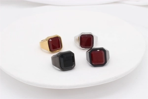 Close-up of square red ruby and black agate rings in gold silver and black steel