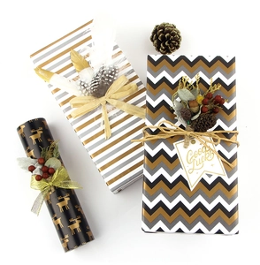 Flat lay of holiday wrapping paper with gold deer, stripes and chevron patterns