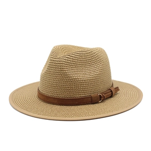 Détail du tissage du chapeau de paille avec ruban marron et boucle dorée