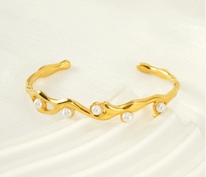 Macro shot of 18K gold plated cuff bracelet with irregular lava texture and white pearls
