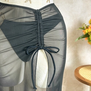 Detail of black mesh sarong cover-up with adjustable drawstring and ruched texture