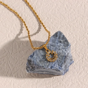 Close-up of 18K gold plated smiling face pendant with zircon on a twisted rope chain