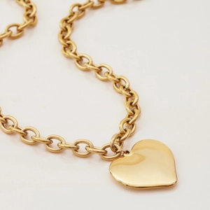 Detail view of chunky gold-plated chain link necklace with large heart-shaped pendant
