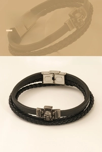 Detail der Totenkopf-Schließe aus Edelstahl und schwarzes geflochtenes Lederarmband