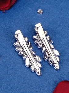 Detailed view of silver hair clips with leaf-shaped crystals and shimmering rhinestones