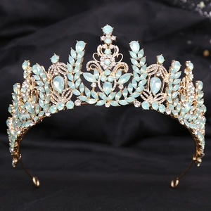 Detailed close-up of golden crown with light blue crystals and micro-pave rhinestones