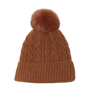 Détails du motif en tricot torsadé d'un bonnet d'hiver avec un gros pompon en fourrure