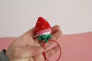 Macro detail of handmade crochet strawberry keychain with durable metal screw ring