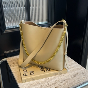 Elegant beige PU leather tote bag with gold chain strap on a marble surface