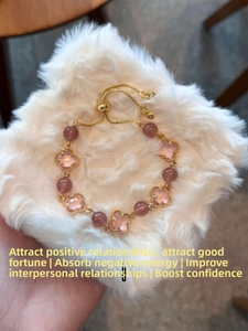 Détail du bracelet ajustable en or avec pendentifs trèfles roses et perles translucides