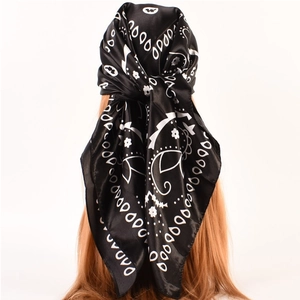 Detail showing back view of black paisley silk satin scarf tied on golden hair