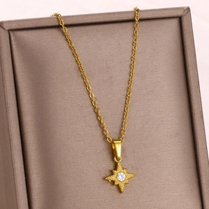 Macro shot of gold star pendant with zircon stone in a brown jewelry display case