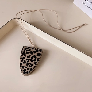 Detailed view of leopard print faux leather glasses case with hanging neck strap lanyard