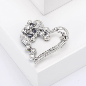 Detailed back view of a silver heart brooch with a secure pin clasp and blue crystals
