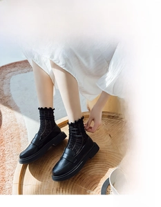Detail von schwarzen durchsichtigen Polka-Dot-Socken mit Spitze und Plateau-Loafers