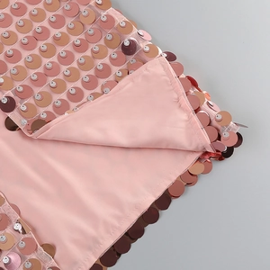 Close-up of pink sequins and satin lining detail on a luxury split party dress