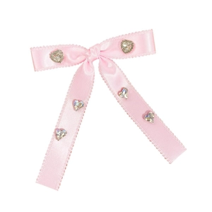 Detail of pink satin bow hair clip with wavy edges and sparkling crystal hearts