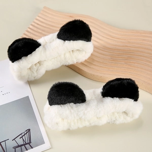 Cute plush panda ear headbands for washing face on a wavy wooden tray with soft lighting
