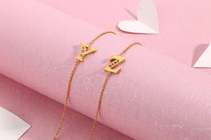 Macro detail of gold O-chain bracelet featuring sparkling Y and Z letter charms