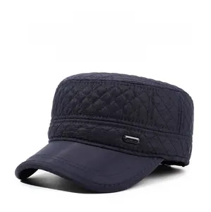 Detail view of quilted blue winter cap with padded ear flaps and side metal accent