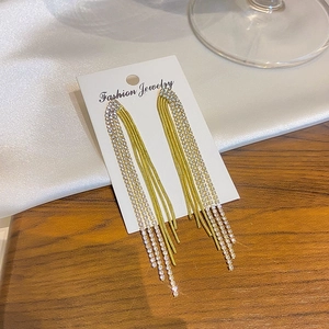 Detailed macro of elegant long tassel earrings with sparkling crystals and gold chains