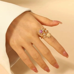 Anello a sole dorato con gemme rosa e zirconi bianchi indossato da una modella