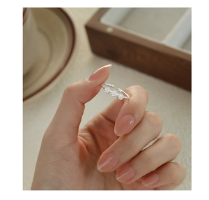 Close-up of three small silver plum blossoms on an adjustable s925 silver ring band