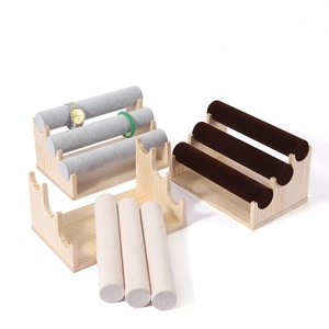 Three-tier wood and velvet jewelry display stand for watches and bracelets on white background